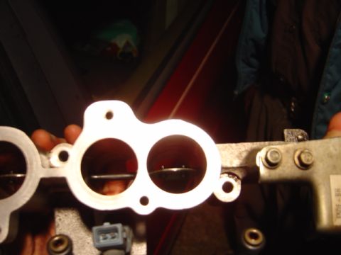 1998 Ford Taurus - A close-up view of a throttle body, a component of the engine's air intake system.