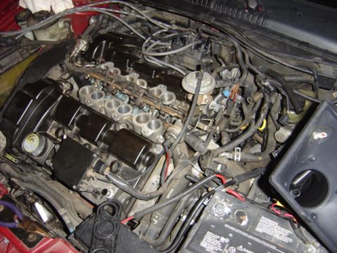 1998 Ford Taurus - Close-up view of a car's engine bay, showing various parts and wiring.