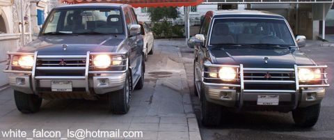 2000 Mitsubishi Montero - Two 2000 Mitsubishi Monteros are shown parked in front of a building.