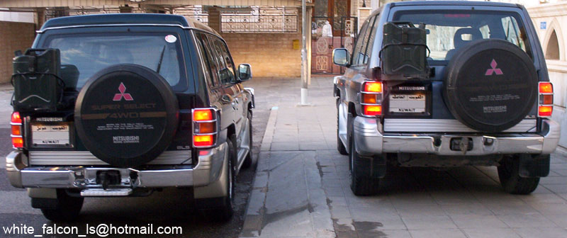 Two Mitsubishi Montero SUVs from rear with spare tire covers and Kuwait badges