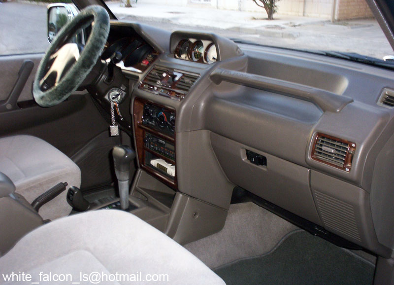 Gray SUV interior with woodgrain dash, auto shifter and fuzzy wheel cover
