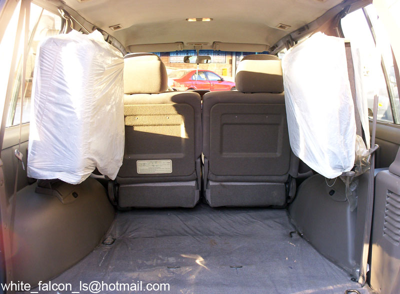 Rear cargo area of an SUV with folded seats and plastic-covered trim panels