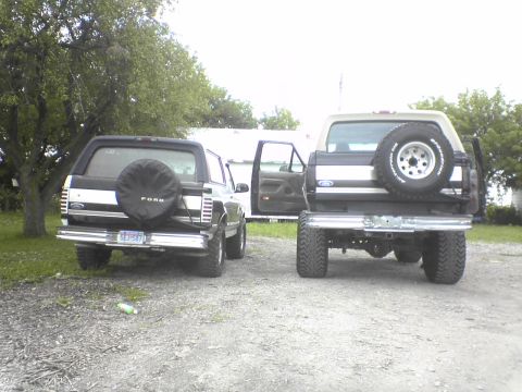 1995 Ford Bronco - Two Ford Broncos are parked outdoors, one slightly behind the other, both facing away from the camera.