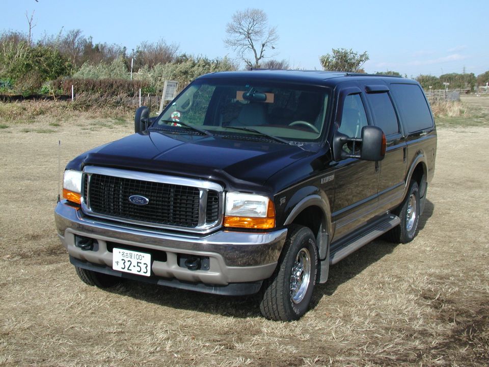 Black Ford Excursion SUV front three-quarter on a field with Japanese license plates and chrome wheels
