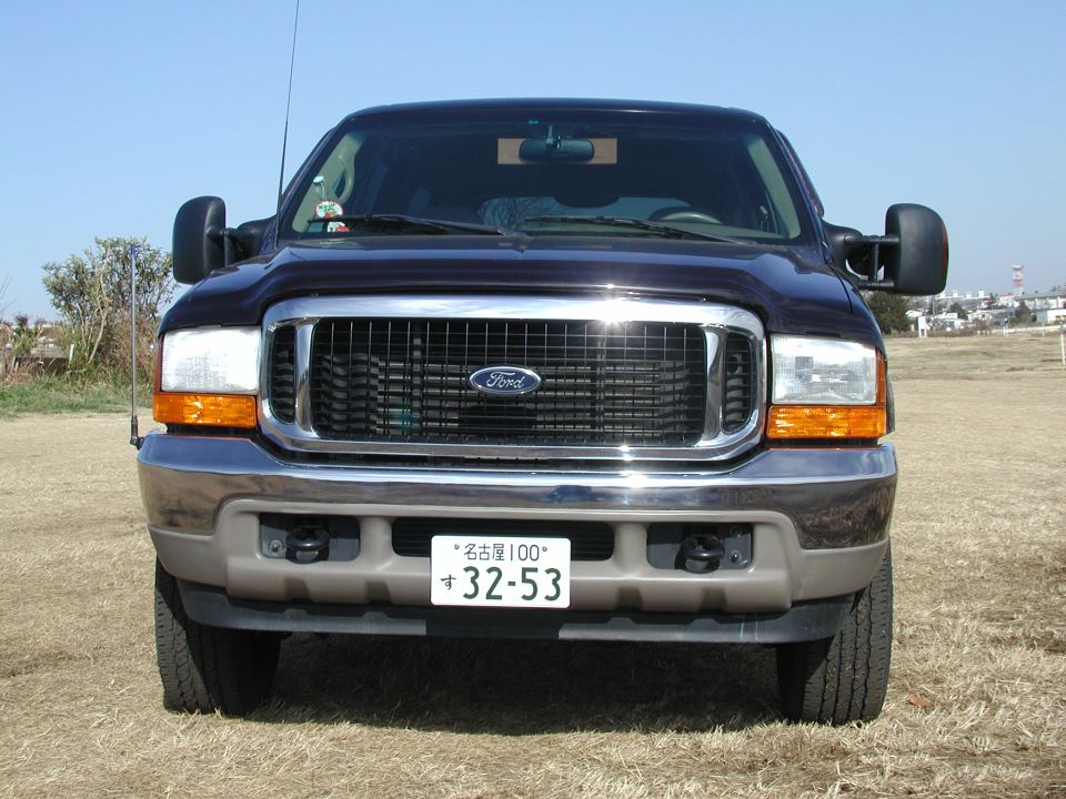 Black Ford Super Duty Excursion front end with chrome grille, Ford oval, and a Japanese license plate