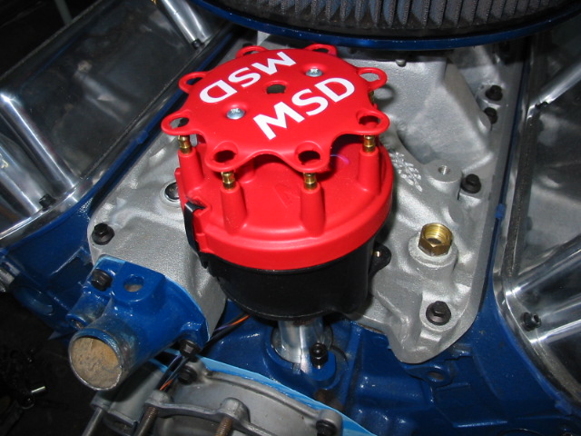 Red MSD distributor cap on a blue and silver engine block with chrome accents