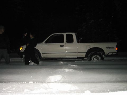 1999 Toyota Tacoma - White 1999 Toyota Tacoma is stuck in the snow during a nighttime event.