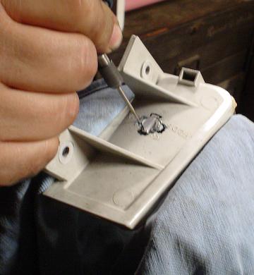 1993 Ford Taurus - Drilling a hole in a plastic car part, possibly for a modification.