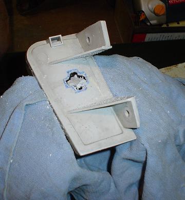 1993 Ford Taurus - A modified plastic bracket with a hole cut out of it sits on a blue cloth.