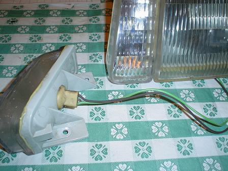 1993 Ford Taurus - Car parts, including headlights and a taillight assembly, are laid out on a checkered cloth.