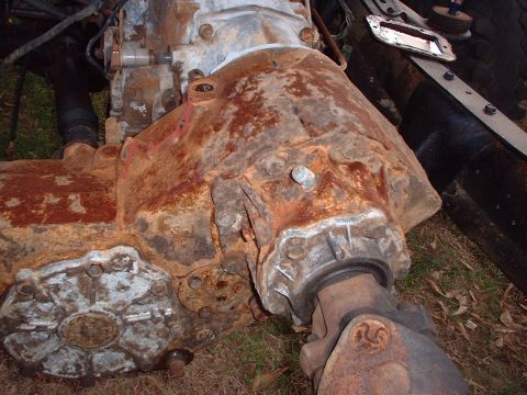1976 Ford F-150 - Close-up view of a heavily rusted transfer case and driveshaft, with a Supermotors.net watermark visible.