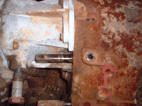 1976 Ford F-150 - Close-up view of a heavily rusted transmission housing and a metal shaft.