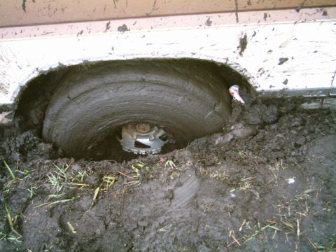 1995 Ford Bronco - This 1995 Ford Bronco is deeply stuck in mud, with only the wheel and part of the fender visible.