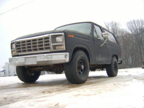 1985 Ford Bronco - This dark gray SUV, likely from the early 1980s, is parked in a snowy outdoor setting.