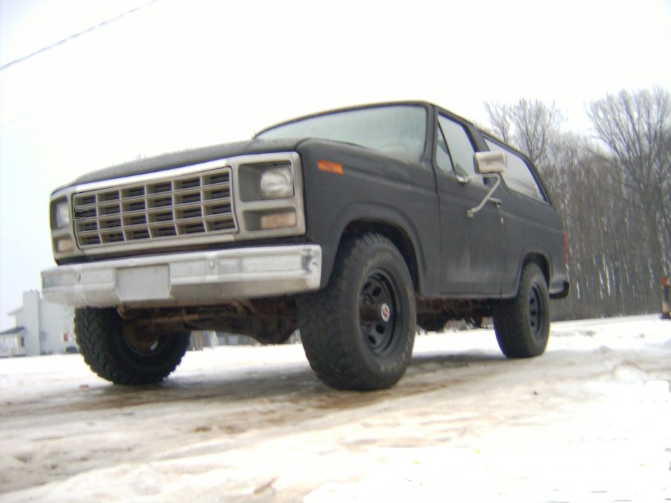 Dark gray SUV front 3/4 view in snow. Chrome grille and bumper