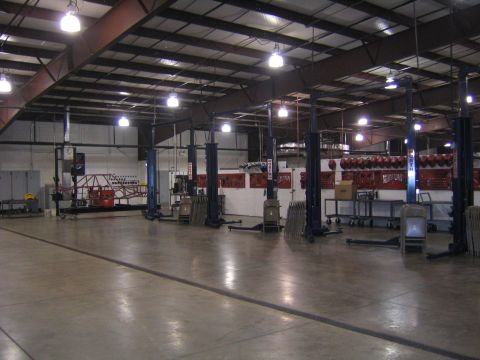 1978 Ford Bronco - This is a view of the inside of a large auto repair shop with several car lifts and organized tool storage on the walls.