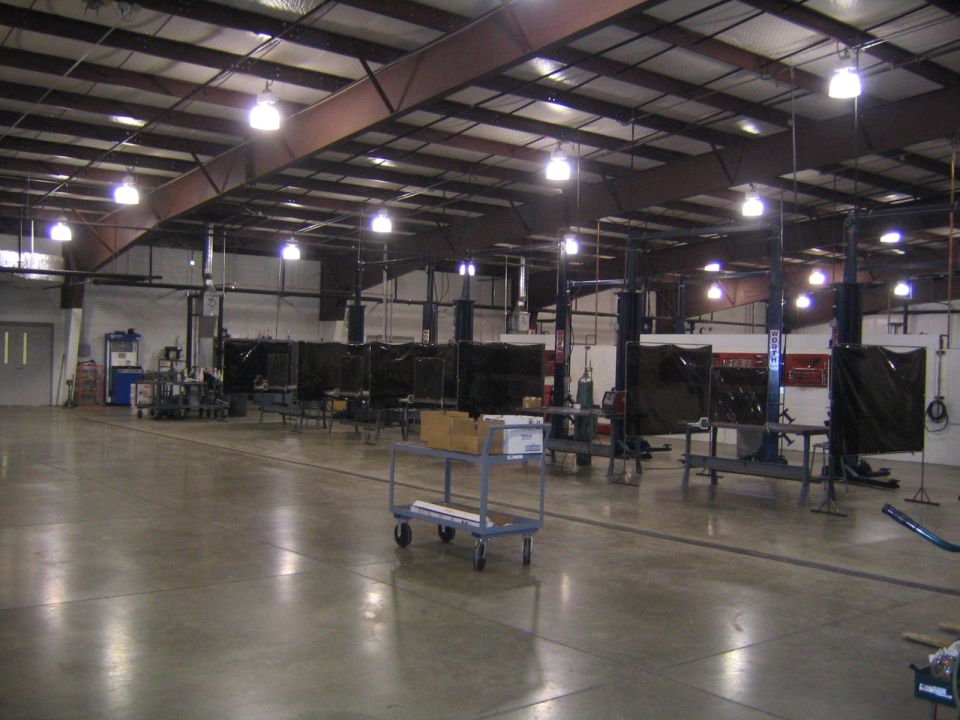 Interior of an auto repair shop with multiple car lifts and welding stations