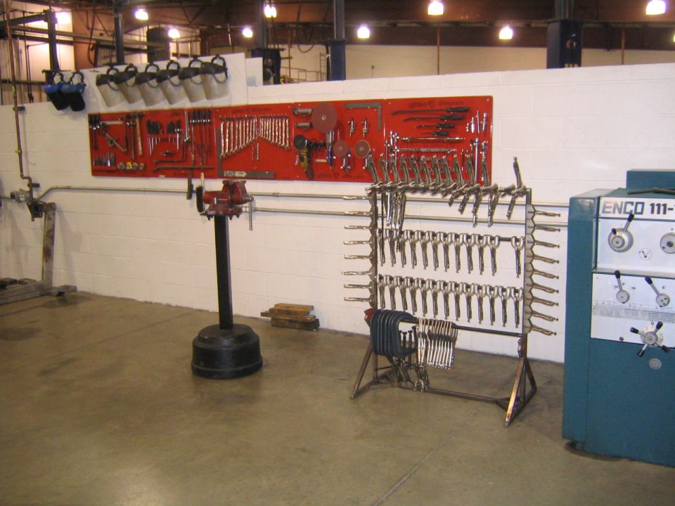 Workshop interior with tool boards, a vise, and a large machine