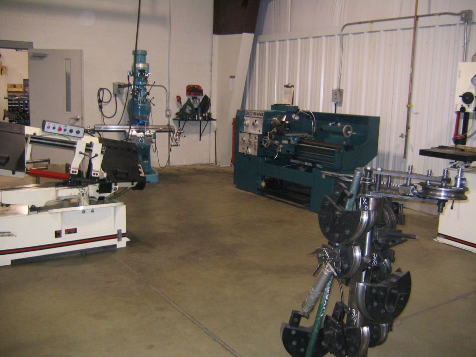 Machine shop interior with multiple industrial lathes and milling equipment. A "Supermotors.net" watermark is visible