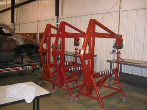 1978 Ford Bronco - Workshop scene with multiple engine hoists and a car body undergoing repairs.