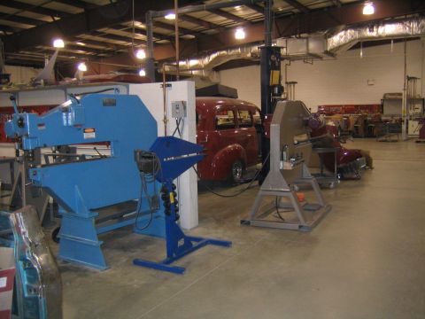 1978 Ford Bronco - A red sedan is visible in a workshop setting, surrounded by various metalworking tools and machinery.