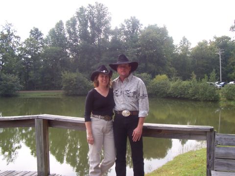 1994 Ford Bronco - A couple dressed in cowboy attire poses for a photo by a calm lake on an overcast day.