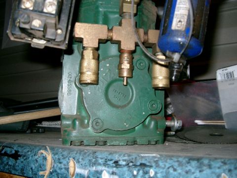 1996 Ford Bronco - Close-up of an air compressor component, showing brass connectors and a blue filter canister.