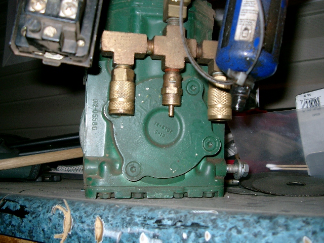 Green cast-iron compressor pump head with brass tee and quick-disconnect couplers