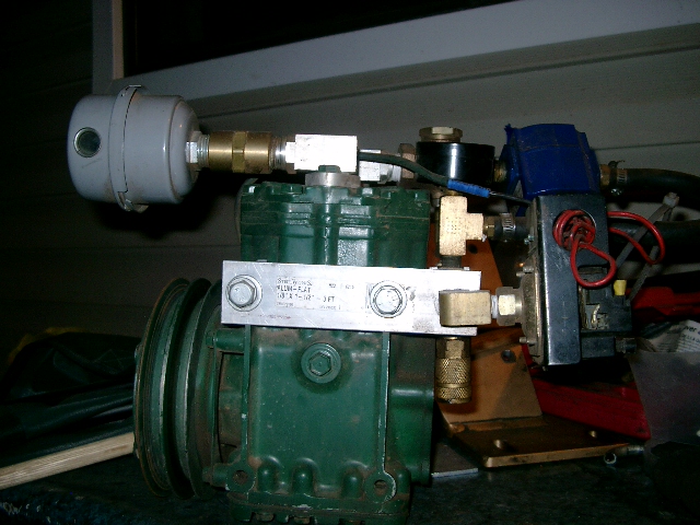 Green York-style piston air compressor with belt pulley, brass fittings and inline filter