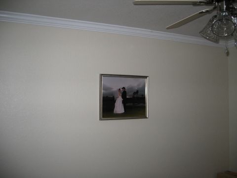2002 Ford Taurus - A framed wedding photograph hangs on a textured wall, with a ceiling fan visible above.