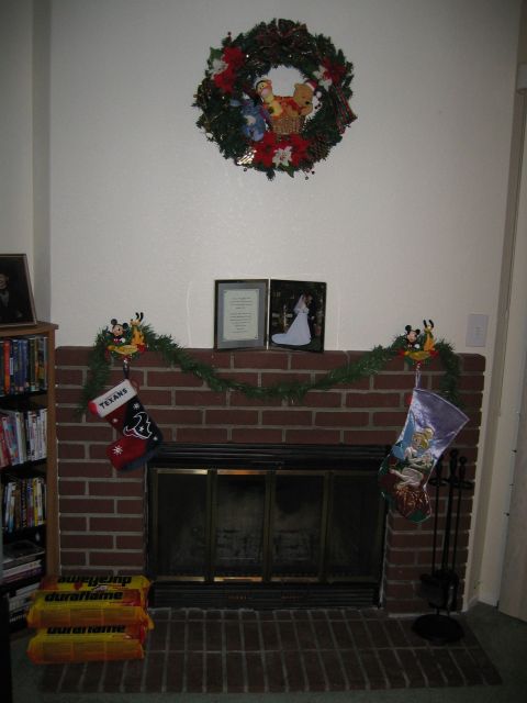 2002 Ford Taurus - A decorated fireplace with Christmas stockings, a wreath, and framed pictures on the mantle.