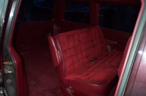 1988 Ford Bronco - The interior of the vehicle shows plush red velour seating and carpeting.