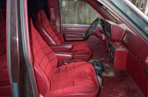 1988 Ford Bronco - The interior of a van features maroon velour seats and matching upholstery.