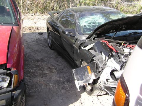 1989 Ford Bronco - Two vehicles involved in a collision, one a black sports car with a damaged front end and windshield.