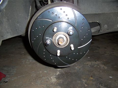 1998 Mercury Sable - Close-up of a vehicle's brake rotor assembly, showing drilled and slotted design.