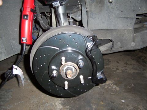 1998 Mercury Sable - A new drilled and slotted brake rotor and caliper are shown, with a heat gun in the background.