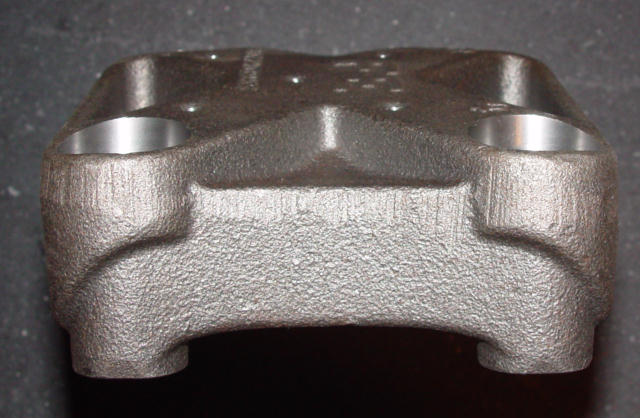 Bare cast iron disc brake caliper half showing two machined piston bores