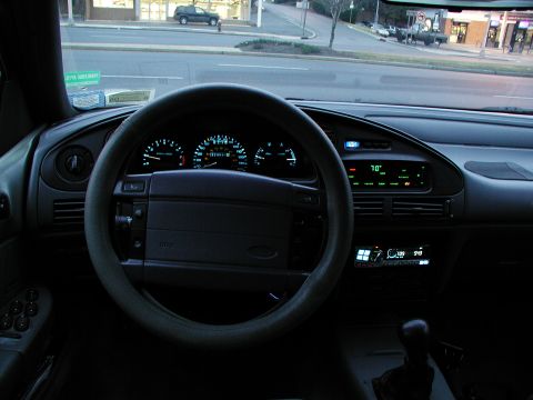 1992 Ford Taurus - The illuminated dashboard of a 1992 Ford Taurus displays digital climate control and a radio unit.