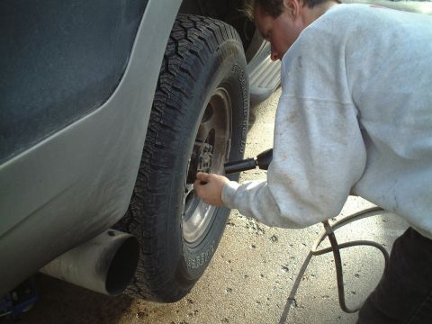 2000 Ford Excursion - Working on the wheel of a large SUV, likely changing a tire or performing maintenance.