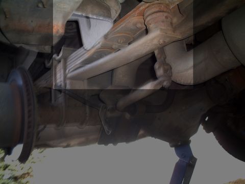 2000 Ford Excursion - Close-up view of the underbody suspension system, showing leaf springs and a brake rotor.