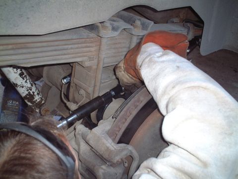 2000 Ford Excursion - Working on the rear suspension of a vehicle, likely a truck or SUV.