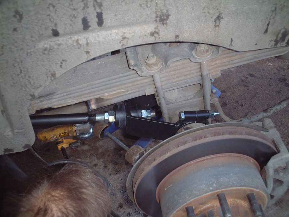 Undercarriage view of front axle, brake rotor and steering linkage during repair
