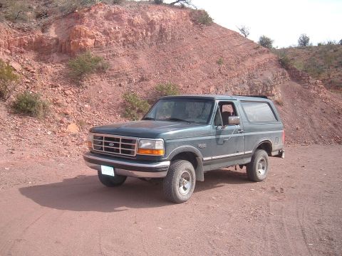 1994 Ford Bronco - 1994 Ford Bronco parked on a dirt road in a rocky, arid landscape.
