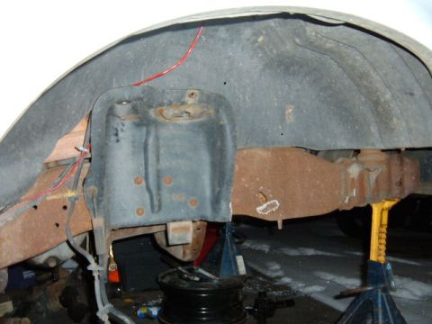 1993 Ford Bronco - The underside of a vehicle shows significant rust on the frame and suspension components.