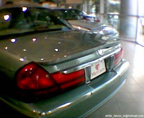 1999 Mercury Grand Marquis - Rear view of a green Mercury Grand Marquis with a visible Mercury emblem on the trunk.