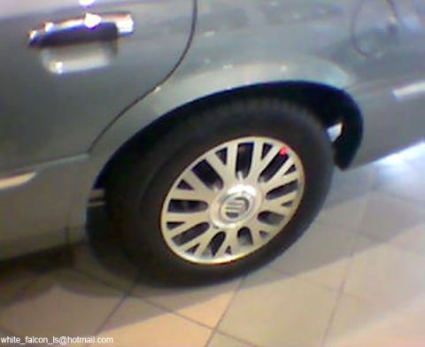 1999 Mercury Grand Marquis - The rear wheel and door handle of a silver sedan are visible in this close-up side view.