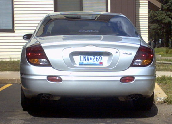 Rear view of silver Oldsmobile Aurora sedan with Minnesota plate LNV 269 and quad exhaust tips