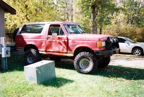 1989 Ford Bronco - This 1989 Ford Bronco is seen parked outdoors next to a white sedan.