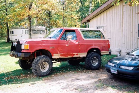 1989 Ford Bronco - This red 1989 Ford Bronco has been modified for off-road use and is parked outdoors.