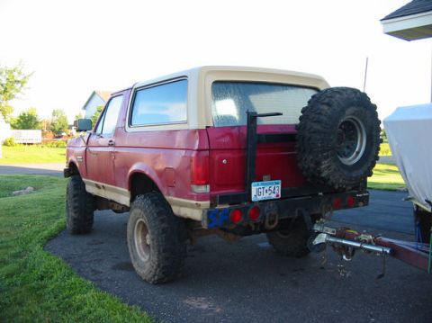 1989 Ford Bronco - This 1989 Ford Bronco is seen from the rear, a spare tire mounted externally and a two-tone red and tan paint scheme.